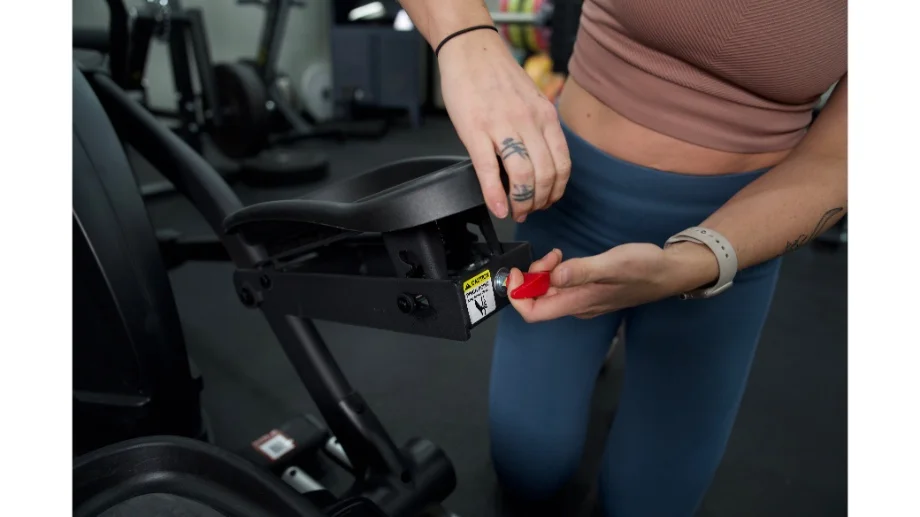 Woman adjusting the footpad of the Sole E35 Elliptical