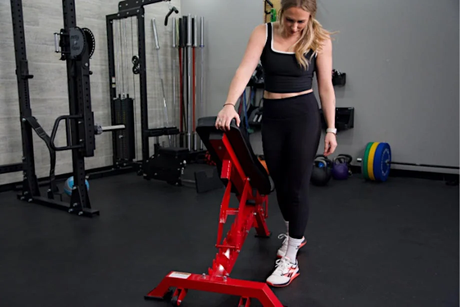 A person lifts the back of a Major Fitness Adjustable Bench to adjust the incline