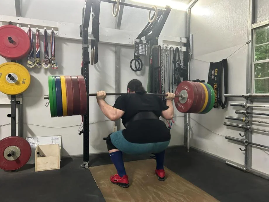 Man squatting with the REP USA Premium Leather Lifting Belt