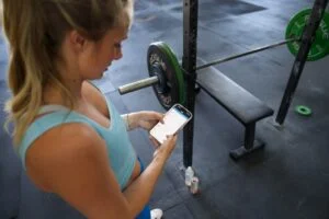 legion fitness app top view from behind scrolling through fitness app on phone