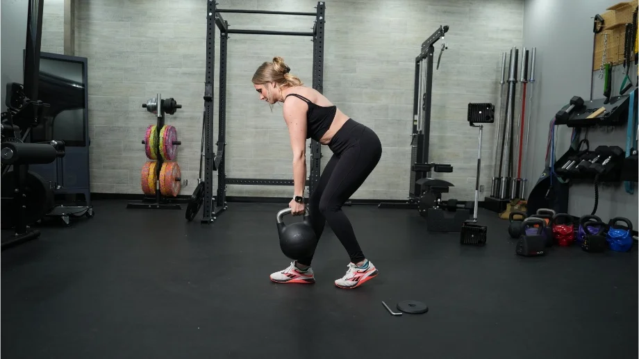 A woman is shown walking with the Bells of Steel Adjustable Kettlebell.