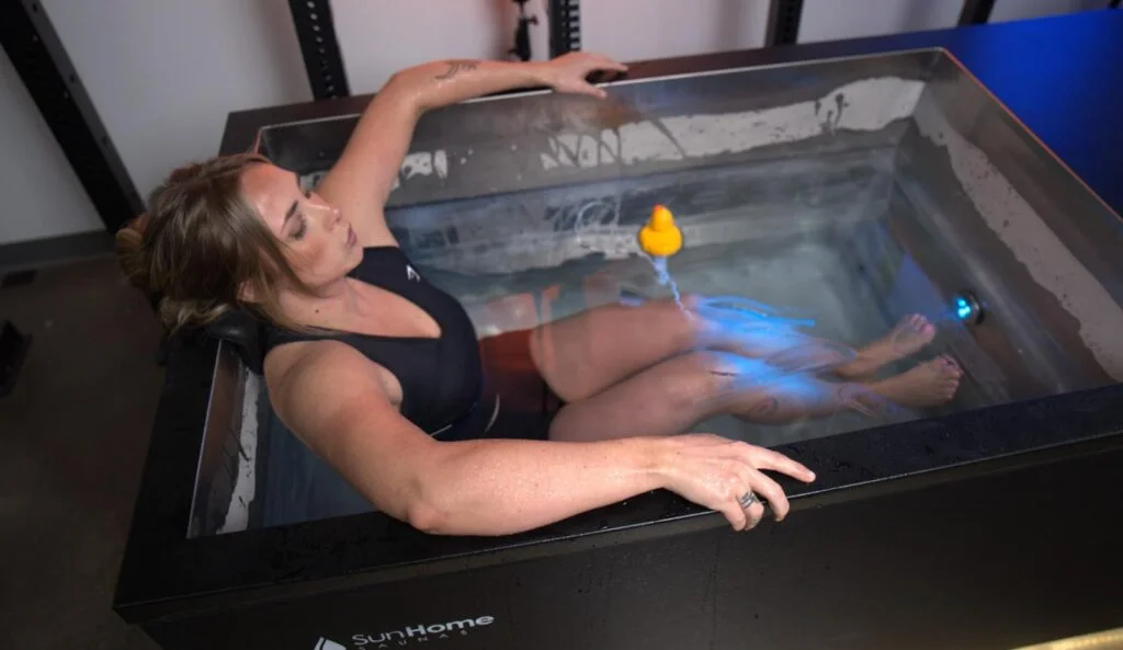 Woman partially submerged in the Sun Home Sauna Cold Plunge Pro