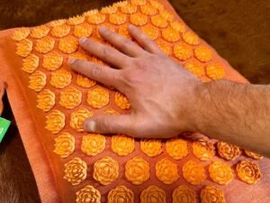ggr pranamat accupressure mat hand resting on lotus spikes