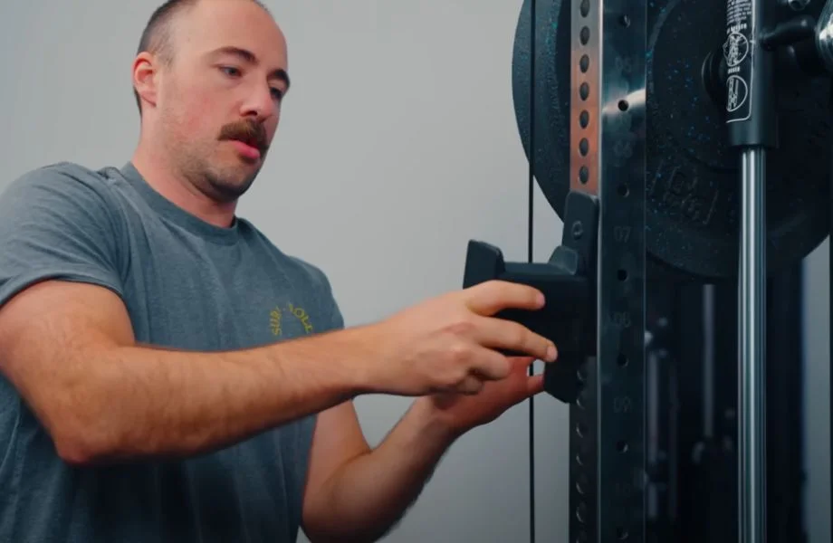 Man moving J-hooks on Force USA G15