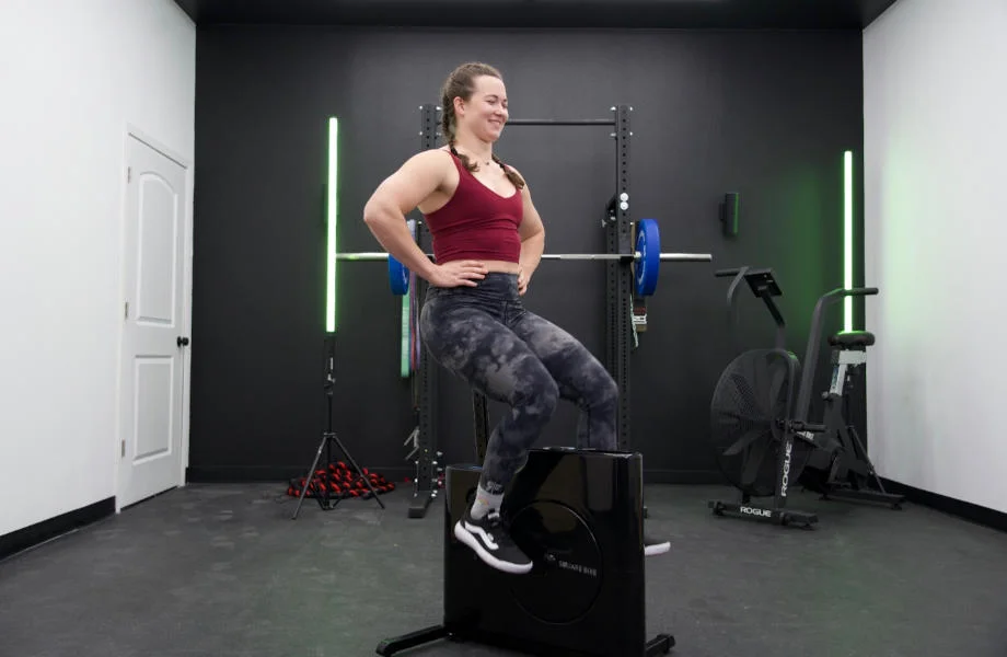 A woman rides the Sharper Image Square Bike with hands on her hips