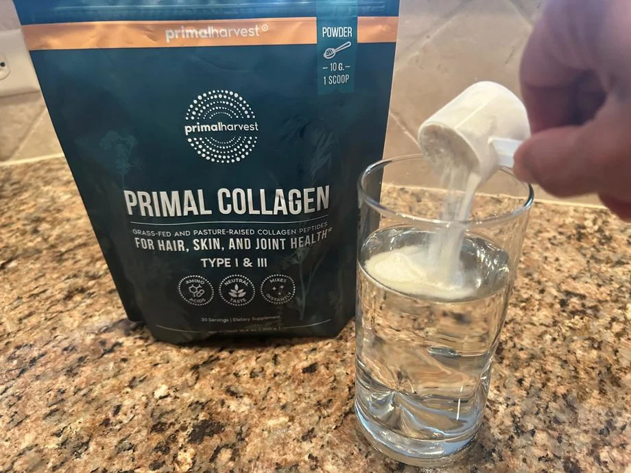 Pouring a scoop of Primal Harvest Primal Collagen in water