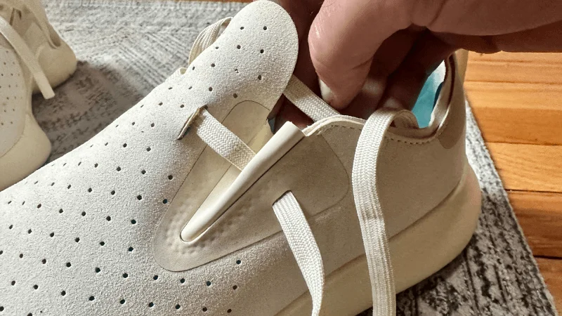 A person laces up a pair of Native Apollo 10 recovery shoes.