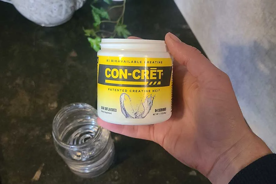 Someone Holding A Container Of Con Crete Creatine