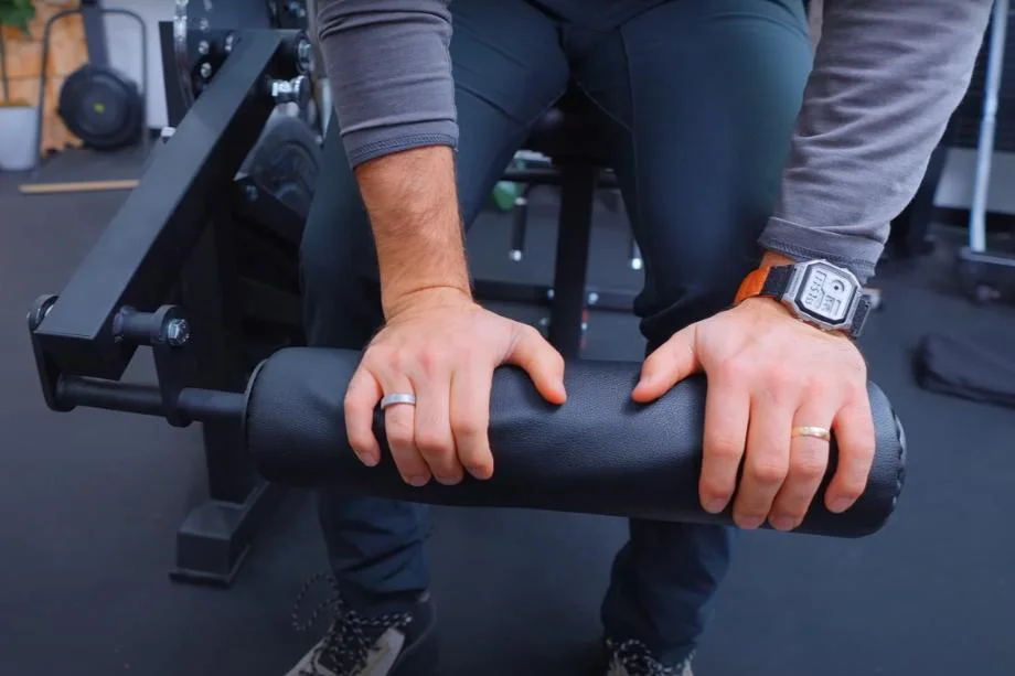 Coop examines the leg pads on a RitFit PLC01 Leg Extension Curl Machine