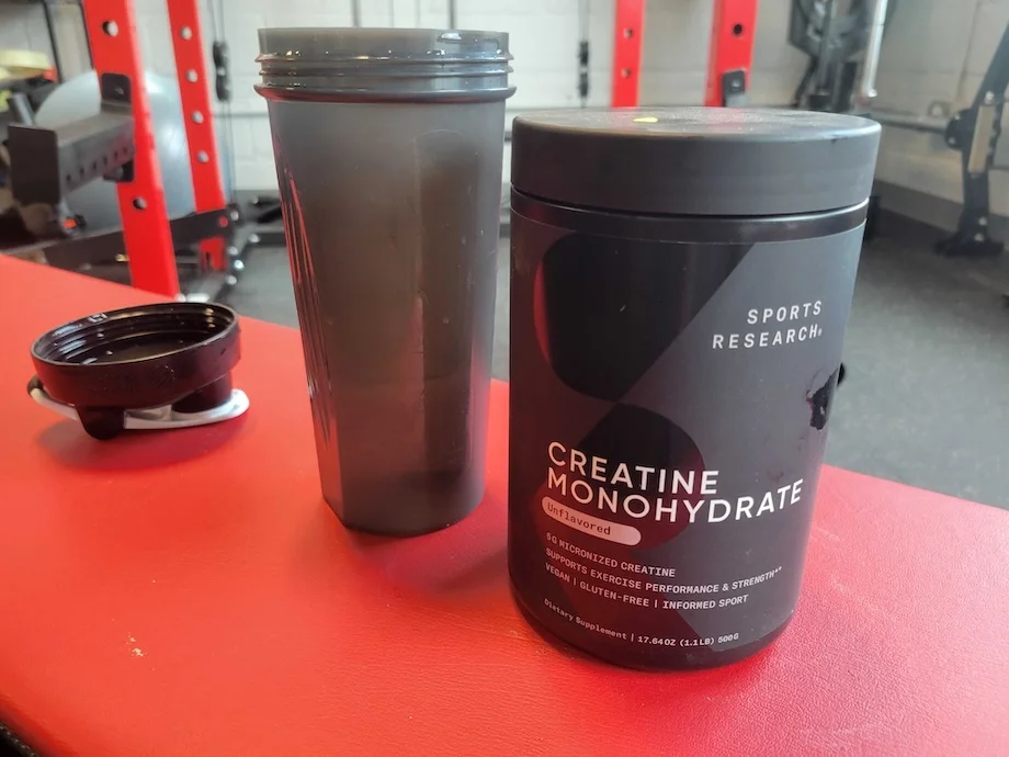 Container of Sports Research Creatine Monohydrate nexts to a shaker cup