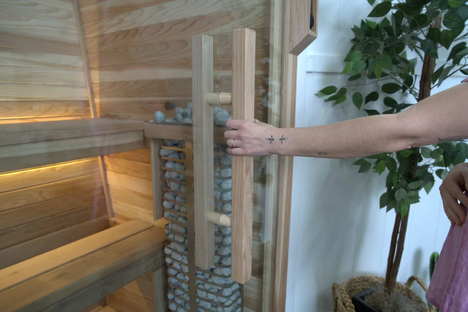 Our tester grabs the wooden handle of a Plunge The Sauna Mini