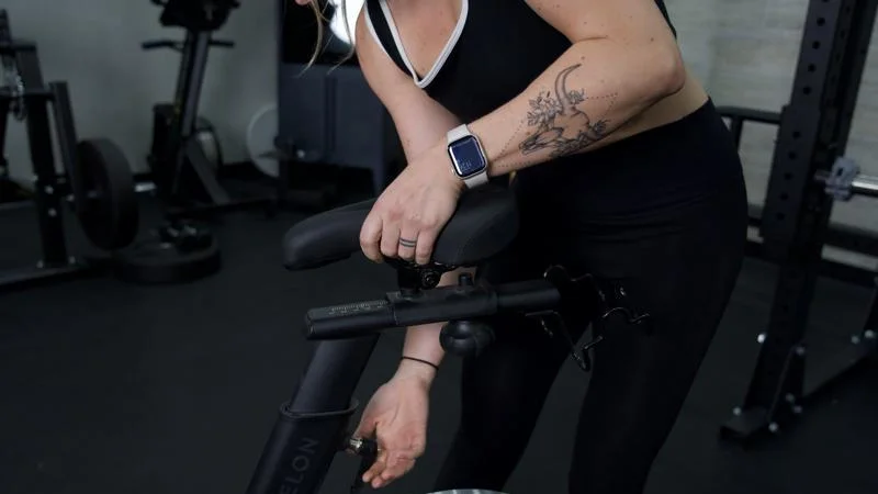 Our tester adjusts the seat height on an Echelon EX-5 exercise bike