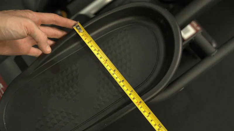 Our product tester measures a pedal on the Sole E25 Elliptical.