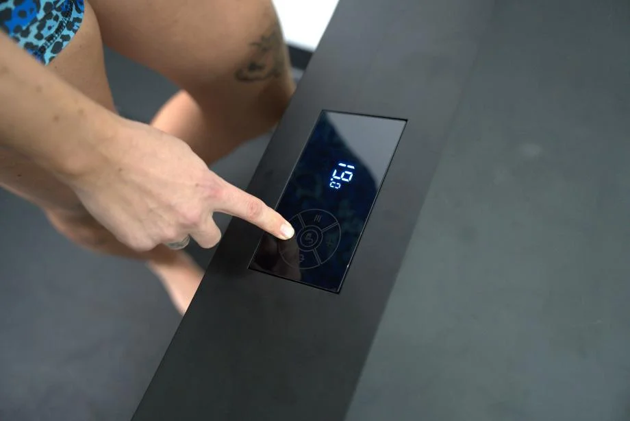 A woman sets the temperature on the Nordik Recovery Ice Tub chiller