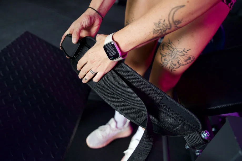 A person holds up the waist strap for a Bells of Steel Hip Thrust Machine