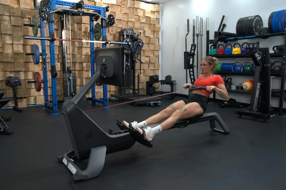 A woman uses the Peloton Row for her cardio workout