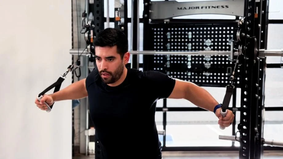 A man performs chest flyes while using the Major Fitness B17