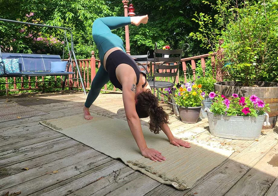Woman doing a downward dog scorpion pose on an Oka yoga mat