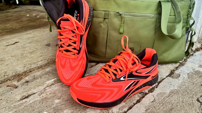 A pair of Reebok Nano X5 shoes next to a gym bag