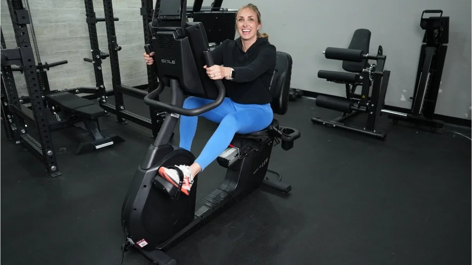 A person smiling while riding the Sole LCR Recumbent Bike
