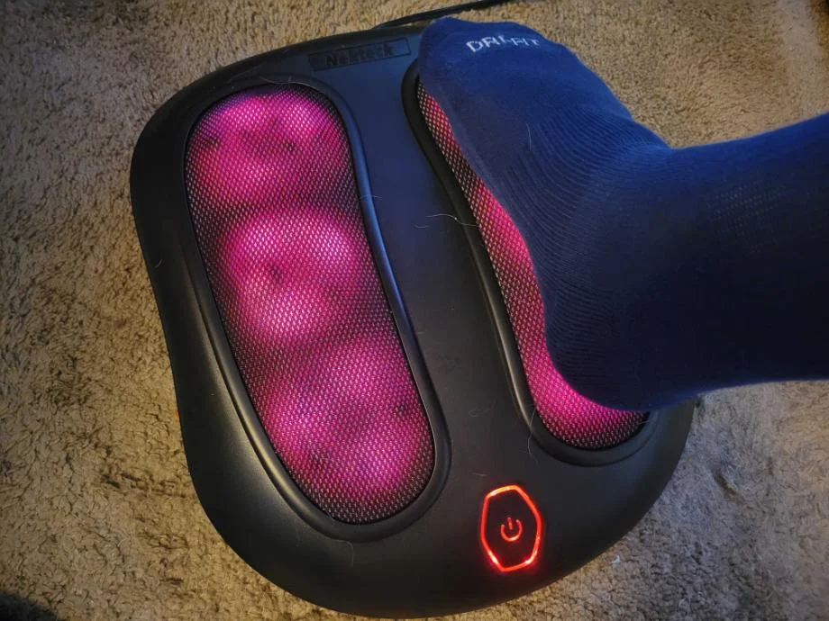 The NekTeck Foot Massager shown in heat mode with somebody's foot on it.