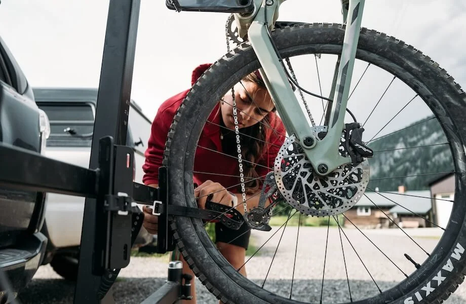 A rider securing their mountain bike to the Jambo Designs Bike Rack
