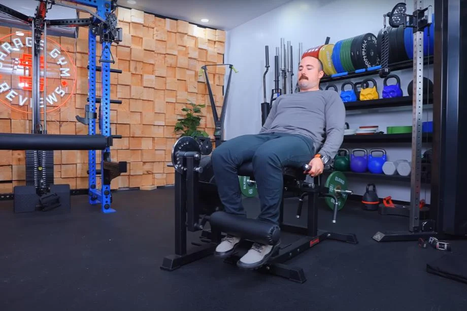 Coop using the RitFit PLC01 Leg Extension Curl Machine for a bottom stretch