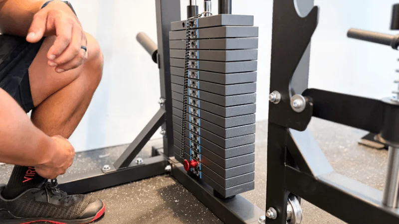 Our tester adjusting their selected weight on one of the Major Fitness B52 Pro's weight stacks