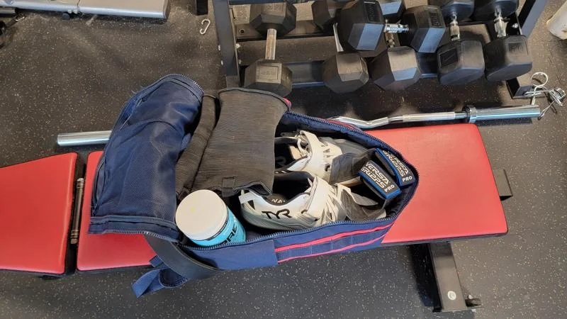Looking down into a gym bag on top of a weight bench