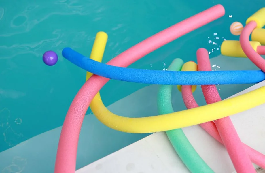Image of a pool with pool noodles floatin on the edge