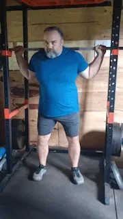 Man doing a back squat in the squat rack 