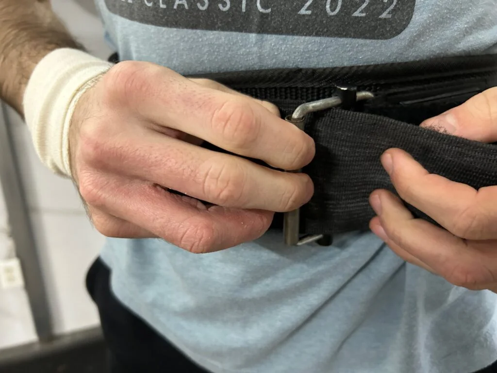 A person adjusting the Gymreapers Quick-Lock Belt