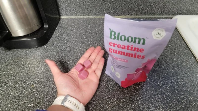A person holding a few creatine gummies from Bloom