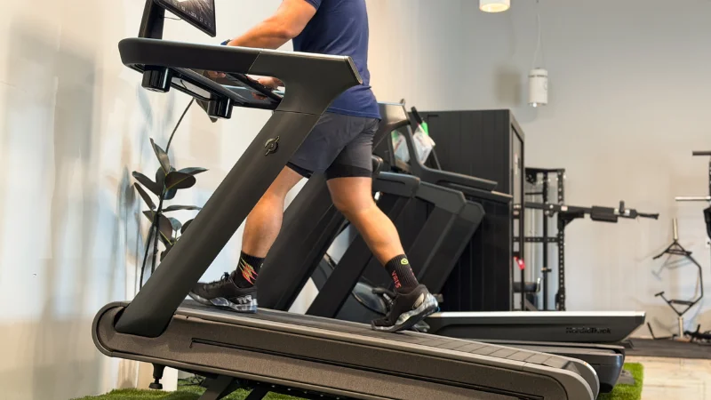 Side view of a person testing the incline settings on the Peloton Cross Training Tread+