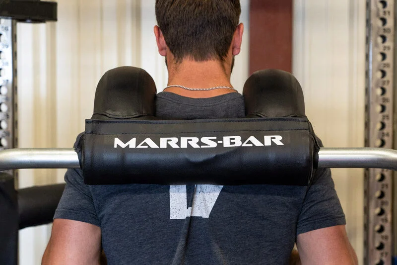 Rear view of man standing with the Marrs-Bar on his shuolders