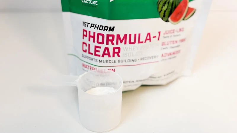 A scoop of 1st Phorm Phormula-1 Clear Protein Powder next to the bag A scoop of 1st Phorm Phormula-1 Clear Protein Powder next to the bag