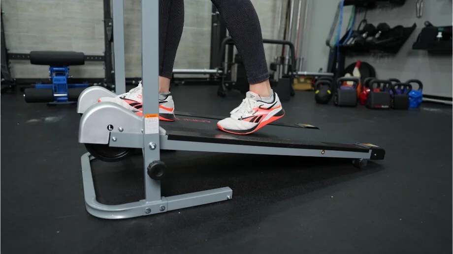 Close up view of product tester walking on the Sunny Health and Fitness Manual Treadmill