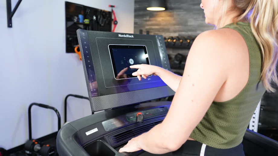 Woman using the display screen of the NordicTrack 1250 Treadmill