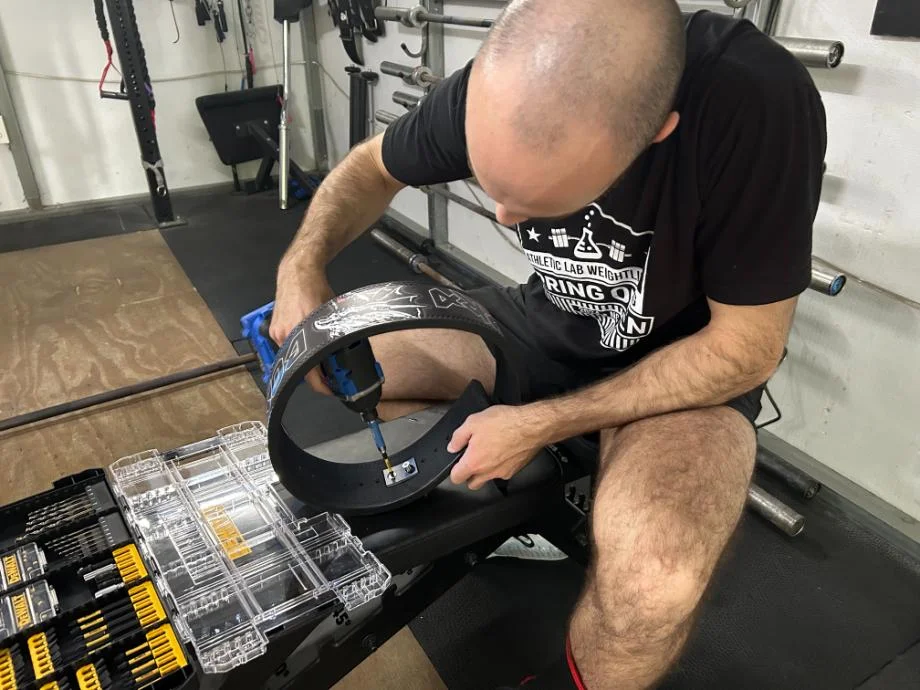 A man makes an adjustment to the Bells of Steel Lever Belt