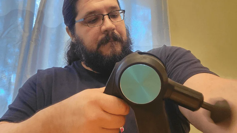 Our tester massaging their bicep with the Therabody Theragun Pro