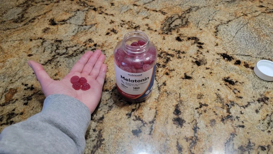 A person holds out some Nutricost Melatonin Gummies.