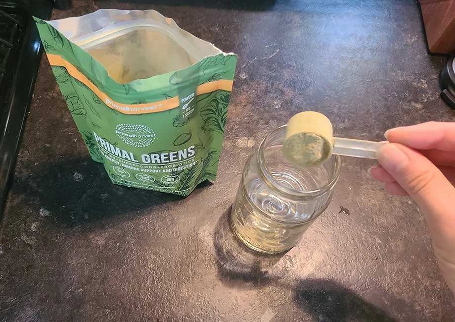 scooping primal greens into a shaker