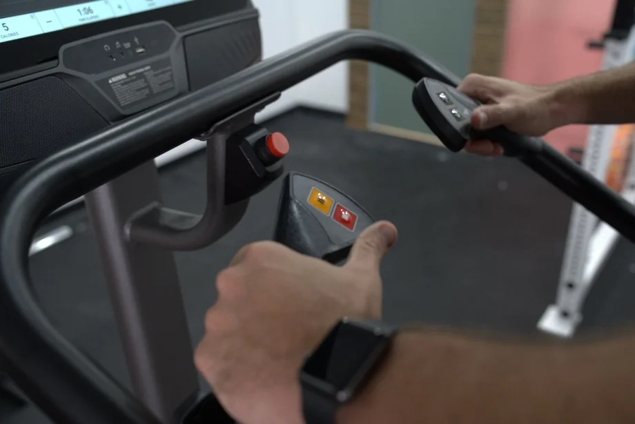 Our tester demonstrates the hand controls on a Matrix C50 Climbmill