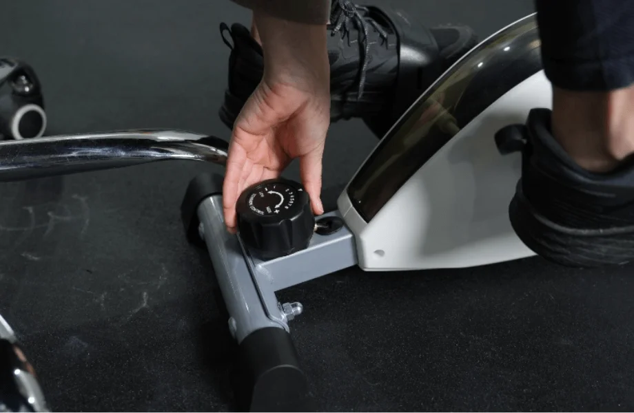 Our tester adjusting the resistance of the DeskCycle 2 Under Desk Exercise Bike And Pedal Exerciser