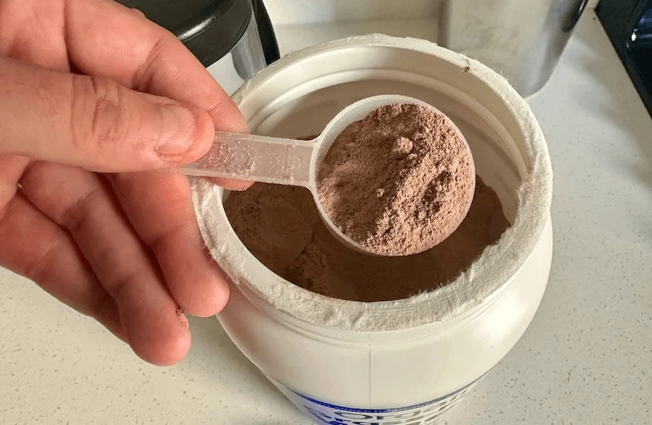 Our tester grabbing a scoop of Orgain Grass-Fed Whey Protein