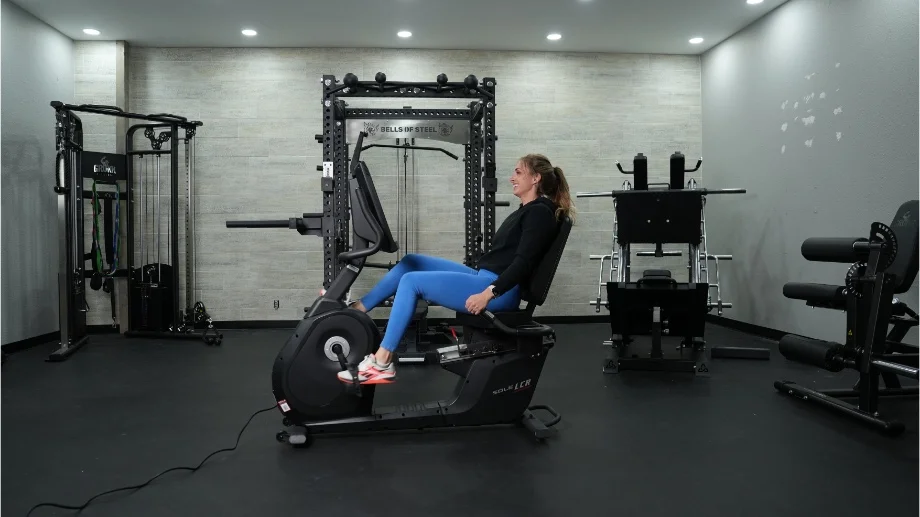 Full side view of a person riding the Sole LCR Recumbent Bike.
