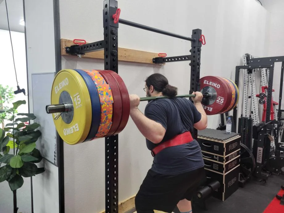 Man about to unrack a bar from the Giant Lifting Wall Rack 2.0