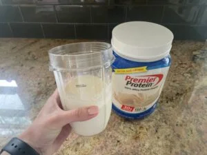 woman holding premier protein powder shake