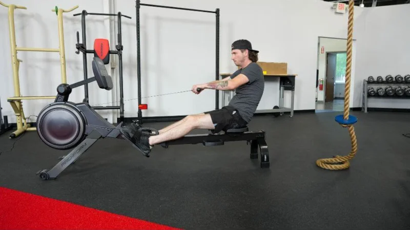 A man in a gym setting using a Proform 750r rower