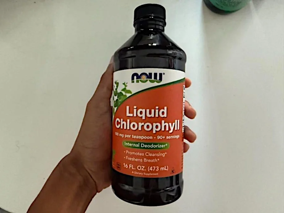 Our tester holds up a bottle of NOW Foods Liquid Chlorophyll